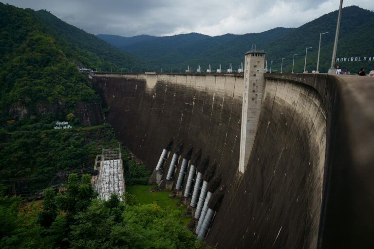 Bhumibol Dam in Ban Na, Tak, Thailand, surrounded by lush greenery and mountains.