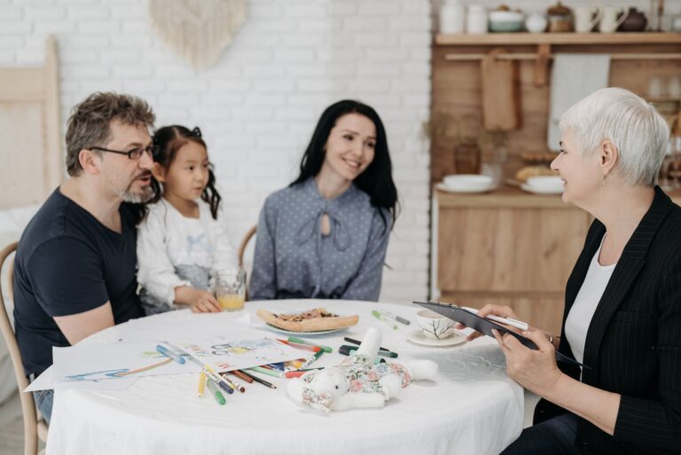 Adoptive family discussing with a social worker indoors, creating a warm, welcoming atmosphere.