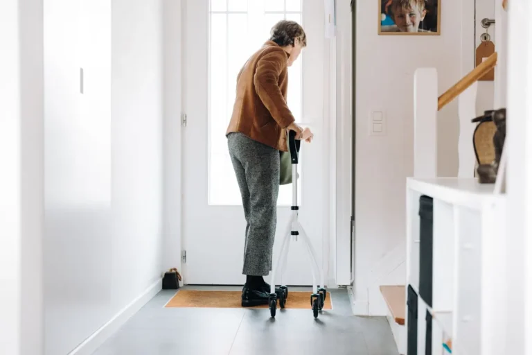 Senior adult using a rollator indoors, embracing mobility aid with confidence.