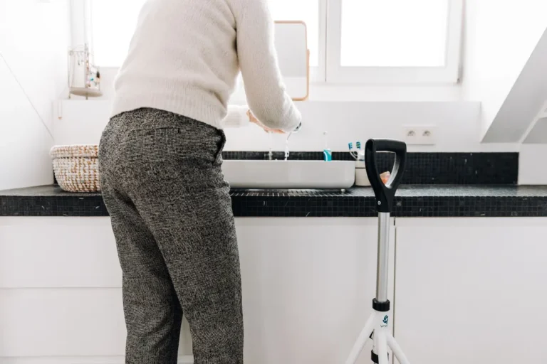 A senior adult using a rollator in a modern bathroom with sleek design elements.