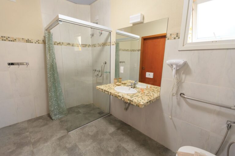 Spacious and accessible bathroom featuring a large glass shower, modern sink, and stylish decor.